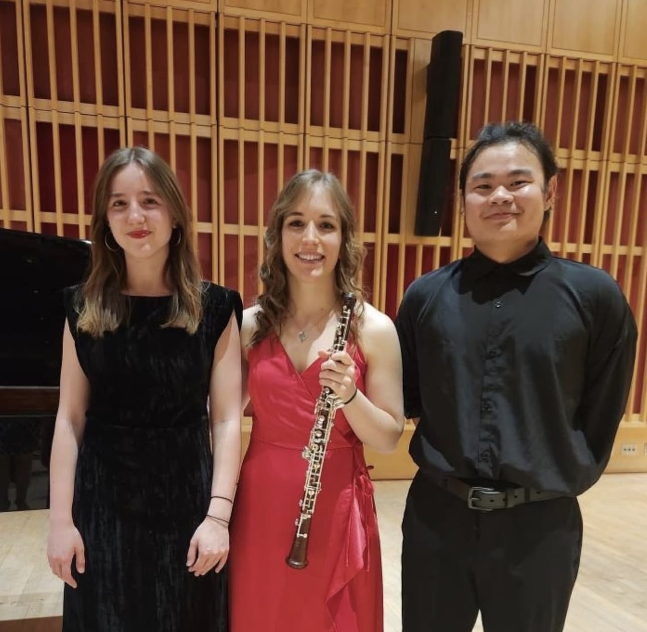 A moment together after making music, in a wood-lined concert hall.